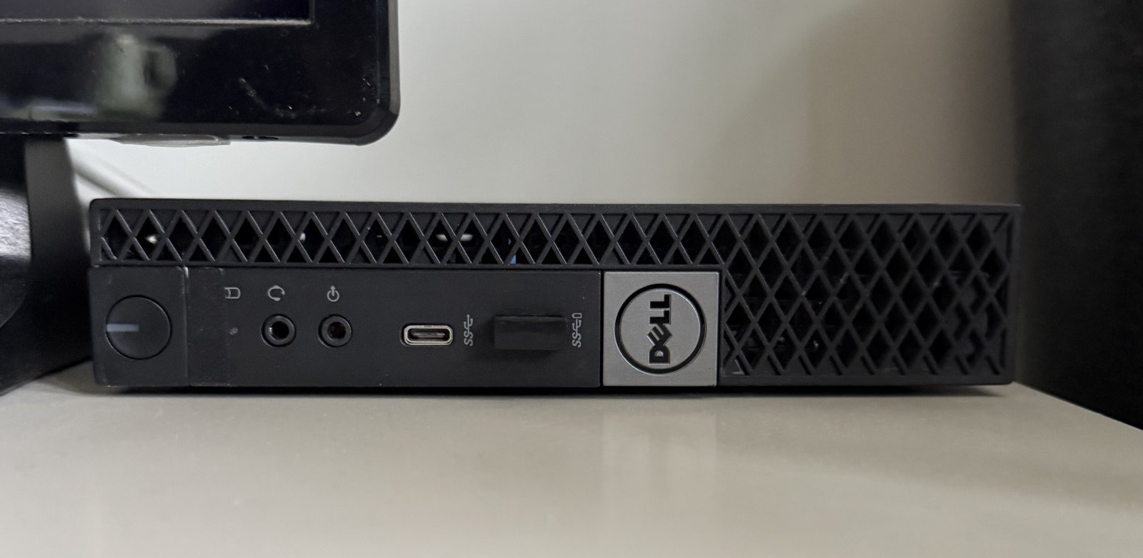 Dell OptiPlex Micro PC — a small black form-factor machine with USB-C, USB-A, audio jacks, and power button on the front panel.